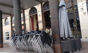 Las sillas y mesas de un bar cerrado cogen polvo a la espera de tiempos más prósperos en una céntrica plaza de Zaragoza.