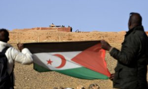 Fotografía de archivo de dos hombres sujetando la bandera del Frente Polisario en el Sáhara.