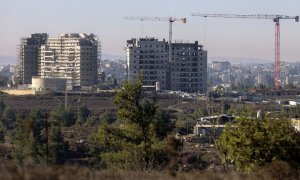 Nuevos edificios de apartamentos en construcción en el asentamiento de Beit El en la ocupada Cisjordania con la ciudad palestina de Ramallah al fondo.