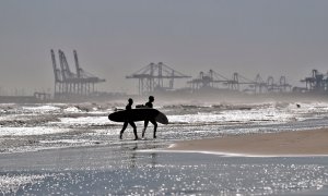 Dos surfistas salen de la playa de La Malvarrosa de València donde las olas y el cielo despejado han animado a numerosas practicantes de este deporte a acercarse al mar.