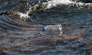 Una botella de plástico flota sobre las olas del mar.