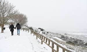 Una pareja camina por la nieve en la localidad madrileña de Los Santos de la Humosa.
