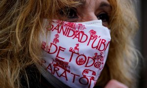 Una mujer con mascarilla, con lemas a favor de la sanidad pública, en una manifestación en Madrid.