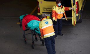 Dos técnicos de ambulancias trasladan a un paciente en el Hospital del Mar de Barcelona, coronavirus