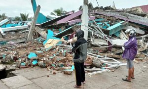 Ciudadanos de la ciudad de Mamuju observan las ruinas de uno de los hospitales afectados por el terremoto.