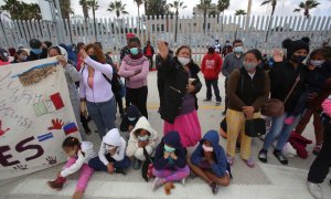 Migrantes rezan en las inmediaciones del cruce fronterizo de El Chaparral, en Tijuana (México)