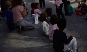 25/03/2021.- Varios niños sentados frente al colegio público Lope de Vega, en Madrid. Jesús Hellín / Europa Press