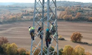 Operarios trabajando en una torre de alta tensión.