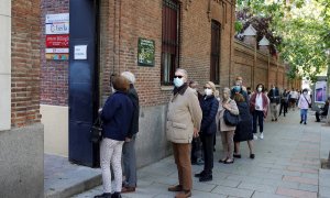Varias personas hacen cola para ejercer su derecho al voto en el colegio electoral de Nuestra Señora de Loreto en Madrid durante la jornada electoral de este martes.