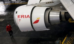Un trabajador de Iberia, en el hangar de mantenimiento en Madrid, pasa junto al motor de un Airbus 330 que ha sido transformado de avión de pasajeros en uno de carga para enfrentar la caída de vuelos debido a la pandemia de coronavirus. REUTERS / Sergio P
