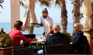 Un cambrer servint una taula en una terrassa de Sitges. Imatge del diumenge 28 de març del 2021.