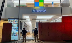 Los miembros de seguridad montan guardia frente a la Microsoft Store destruida en la quinta avenida