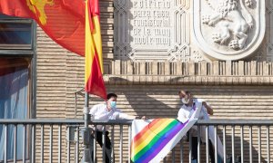 Trabajadores del Ayuntamiento de Zaragoza retiran la pancarta LGTB que había sido colocada esta mañana en el balcón del consistorio.