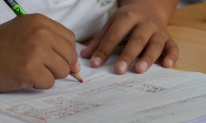 Un niño haciendo deberes en el colegio.