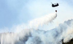 Un helicóptero Chinook apaga un incendio forestal en el área de Malakassa, cerca de Atenas.