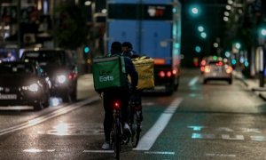 Foto de archivo. Un rider de Uber Eats y de Glovo circulan por las calles de Madrid.