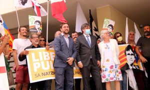 Puigdemont, Comín i Ponsatí a la sortida del tribunal de Sàsser i davant una pancarta de suport.