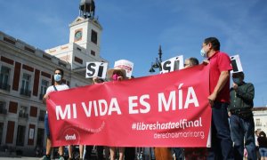Un grupo de personas se reúne sosteniendo pancartas y carteles durante la concentración de la asociación Derecho a Morir Dignamente (DMD) en la Puerta del Sol, a 25 de junio de 2021, en Madrid, (España)