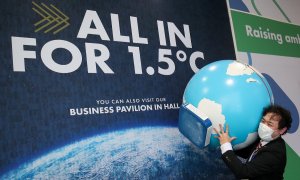 Una persona carga con un globo terráqueo durante la Cumbre del Clima de Glasgow (COP26).