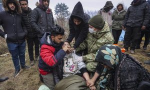 Un médico militar bielorruso brinda atención médica a los migrantes en el campamento en la frontera entre Bielorrusia y Polonia en la región de Grodno, no lejos del puesto de control de Bruzgi, Bielorrusia, el 11 de noviembre de 2021.