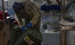 Una trabajadora de la limpieza limpia una papelera durante durante la segunda ola de coronavirus en el Hospital Universitario Ramón y Cajal, en Madrid (España).