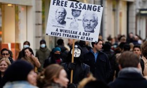 Un manifestante sostiene una pancarta en defensa del fundador de WikiLeaks, Julian Assange, entre los compradores navideños en Oxford Street en Londres.