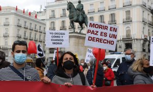 Una mujer con un cartel en el que se lee: `Morir en paz es un derecho´ durante una concentración de Derecho a Morir Dignamente en la Puerta del Sol, en Madrid, a 18 de marzo de 2021.