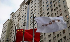 Una bandera con el logo de la promotora inmobiliaria Shimao Group ondea junto a otra bandera de China, en Shanghai. REUTERS/Aly Song