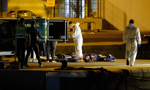 Dos agentes de Policía Portuaria, presencia como los trabajadores de la funeraria se llevan los cadáveres de las tres mujeres migrantes que naufragaron en alta mar en la costa de Lanzarote, en Puerto del Rosario de Fuerteventura, a 25 de agosto de 2021, e