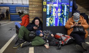 Dos mujeres, junto a un niño recostado, se refugian en el metro de Kiev el pasado 24 de febrero tras al ataque masivo de Rusia a Ucrania.