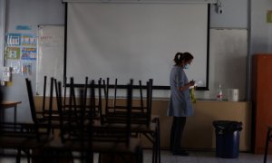 (28/02/2022) Una trabajadora marca un gel desinfectante en el aula de un colegio..
