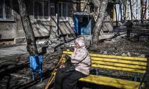 Una mujer llora sentada afuera de un edificio que resultó dañado por un bombardeo en la ciudad de Kharkiv, en el este de Ucrania, el 24 de febrero de 2022, cuando las fuerzas armadas rusas lanzaron una invasión militar de Ucrania.