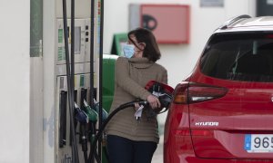 Una mujer reposta combustible en una gasolinera, a 24 de febrero de 2022, en Madrid.