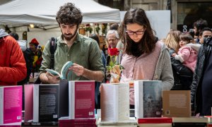 Dos personas miran libros en el día de Sant Jordi en Barcelona.
