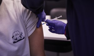 Detalle de una persona, de entre 18 y 29 años, recibiendo la tercera dosis de la vacuna contra la covid-19.