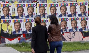 Personas caminan hoy cerca a volantes publicitarios del candidato presidencial colombiano Gustavo Petro, de la coalición Pacto Histórico, en Bogotá (Colombia). Colombia elige este domingo 29 de mayo a su próximo presidente