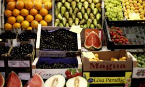 Naranjas, peras, limones, uvas, sandías, melones, fresas y cerezas en un mercado.