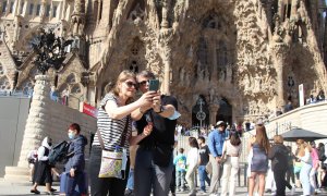 Dos turistes es fan una 'selfie' davant la Sagrada Família.