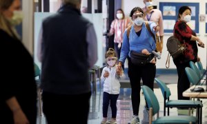 Una mujer y su hija, con mascarillas para evitar contagios de covid-19.