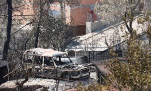 Un vehicle cremat al costat d'una casa a la urbanització de River Park, al Pont de Vilomara.