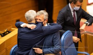 8/8/22 El vicepresidente primero de la Xunta Francisco Conde abraza a Alfonso Rueda en su investidura, mientras Feijóo consulta la hora en su reloj.
