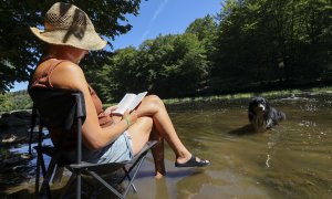 11/08/2022 Una mujer se refresca con su perro en el río "Semois"