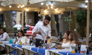 Un camarero atiende a una mesa en las Ramblas, a 15 de junio de 2022, en Barcelona.