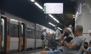 Dos usuaris de Rodalies esperant el seu tren a l'estació de Sants de Barcelona, durant la jornada de vaga dels maquinistes de Renfe d'aquest dijous.