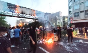 Un grupo de manifestantes iraníes queman un contenedor de basura en la capital, Teherán, durante una protesta por Mahsa Amini, a 21 de septiembre de 2022.