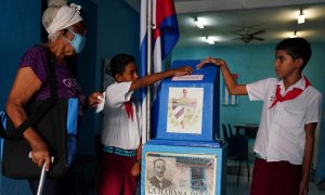 Los niños ayudan a una votante a emitir su voto en un colegio electoral durante el referéndum del nuevo Código de Familia en La Habana, Cuba , el 25 de septiembre de 2022.
