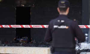 Un agente de policía observa la zona quemada en un local comercial de Alcorcón tras una explosión, a 7 de octubre de 2022, en Alcorcón, Madrid.
