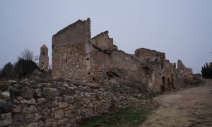 Calle de un pueblo destruido en Corbera de Ebro, y al fondo, el campanario de la Iglesia de San Pedro, bombardeada durante la Guerra Civil.