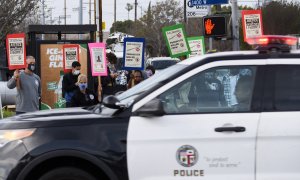 Un coche de la Policía de Los Ángeles pasa junto a una protesta por las muertes de George Floyd y Daunte Wright, a 12 de abril de 2021.