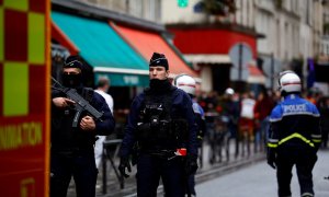 Agentes de policía y bomberos franceses protegen una calle de París después del tiroteo que le ha causado la muerte a dos personas, a 23 de diciembre de 2022.